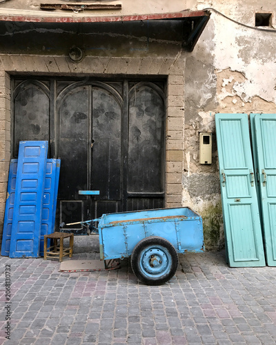 Vintage Blue Doors and Old Wooden Cart in Essaouira Street, Morocco