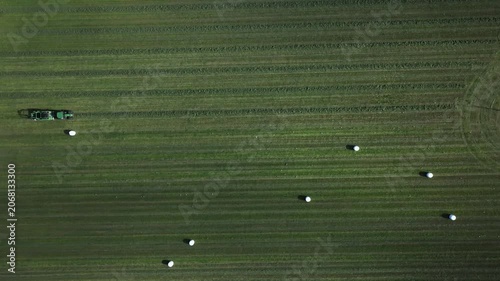 Tractor driving across a large field in rural nature seen from above