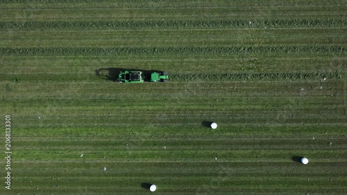 Tractor driving across a large field in rural nature seen from above