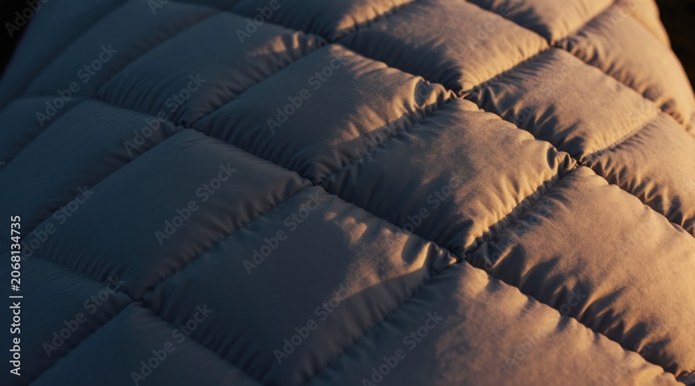 Naklejka premium Closeup of quilted puffer material showing texture and light play. Soft, padded fabric with diamond pattern stitch detail. Warm, modern textile surface.