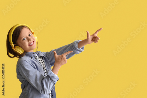 Little girl in headphones p...