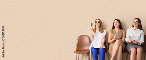Foto Diverse group of women waiting in line, including visually impaired person, for