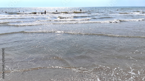 A sea with people swimming. Liquid texture. Summer vacation, seaside holiday. Color photo new