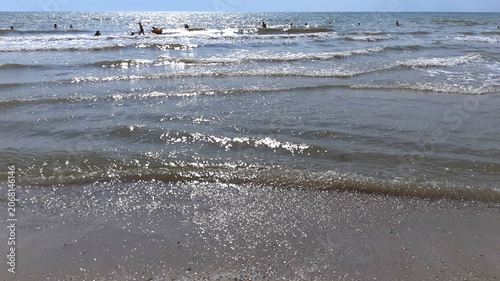 A sea with people swimming. Liquid texture. Summer vacation, seaside holiday. Color photo new