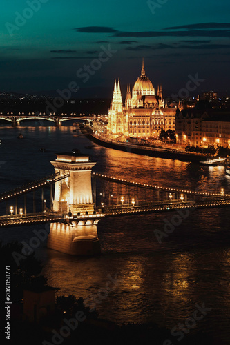 Quadro su tela The illuminated Hungarian Parliament Building and Chain Bridge reflected on the Danube River after sunset