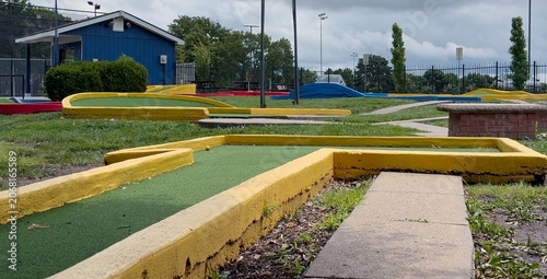 Εκτύπωση καμβά Casual adult woman putting a yellow ball past red, blue, and yellow concrete haz
