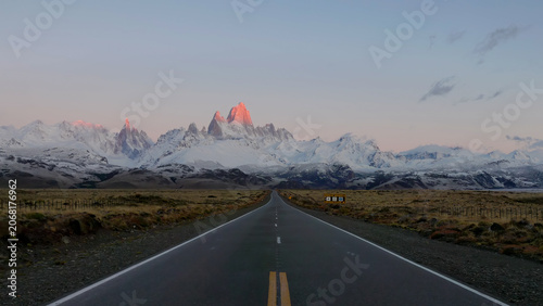 a wide shot of monte fitz roy and the road to el chalten at sunrise after an autumn snow storm in patagonian argentina