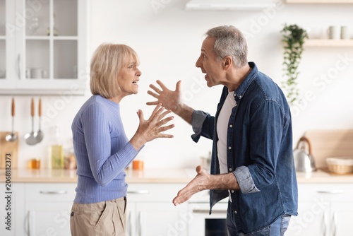 Tableau sur toile Frustrated Elderly Caucasian Couple Engaging In Argument In Kitchen, Expressing Their Emotions With Hand Gestures And Facial Expressions, Creating Tension In Domestic Setting, Conflict Concept