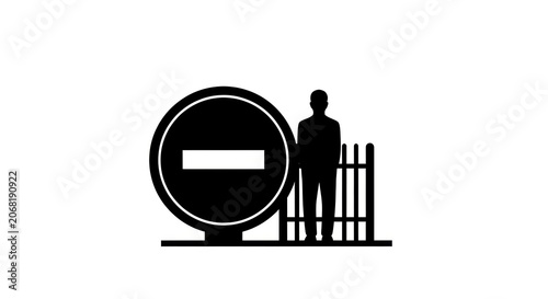 Silhouette of a person standing next to a stop sign and a fence.