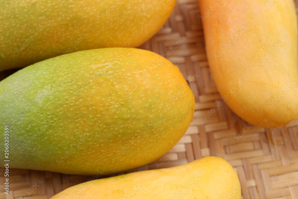Obraz premium Fresh ripe yellow mangoes, delicious and sweet tropical fruits.