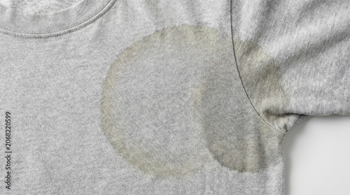 Close up view of a large yellow sweat stain on a grey cotton t-shirt underarm