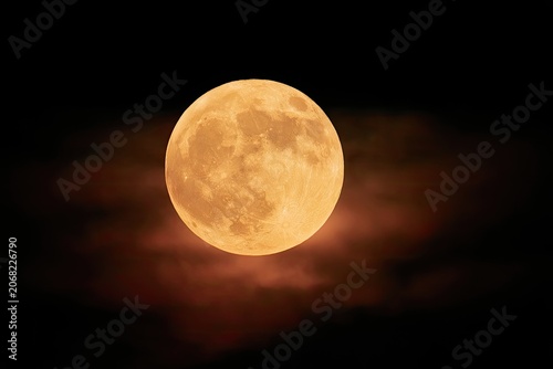 Ethereal, glowing amber full moon emerges through wispy, red-tinged clouds