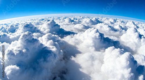 Schilderij op canvas Breathtaking high altitude view of white cumulus clouds from above with clear bl