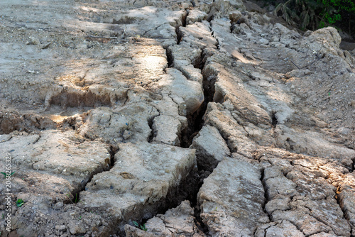 Fotografie Deep fissure splitting dry cracked earth after a landslide or earthquake, showin