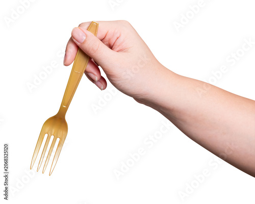 Female hand holding a gold plastic fork isolated on white background.