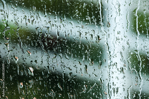 Obraz na plátne Rain water drop glass window wet nature blur green outdoor weather moisture tran