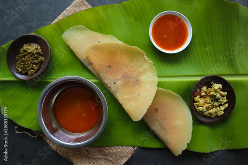 dosa masala. Paper Masala dosa is a South Indian meal served with sambar and coconut chutney over fresh banana leaf.