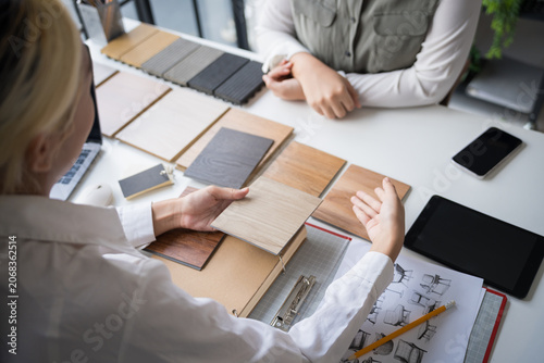 Interior designer presenting eco friendly wooden material samples for sustainable home decor