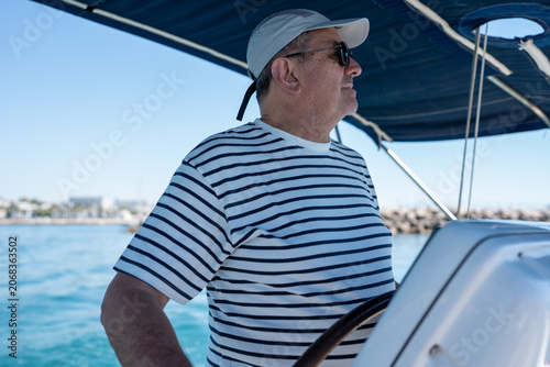 Tableau sur toile Man navigating sailboat on blue ocean vacation