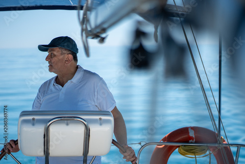 Photos Man navigating sailboat, enjoying leisure on ocean