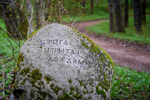 Photos Stone signpost about rain-ridden road in Pushkin Hills, Pskov region of Russia