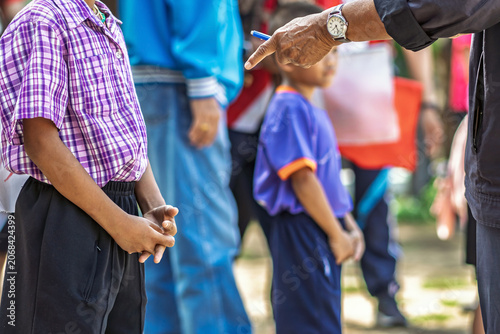 Schoolboy standing with referees checking documents. young schoolboy standing with sports officials and referees holding and checking paper registration documents during outdoor athletic competition.