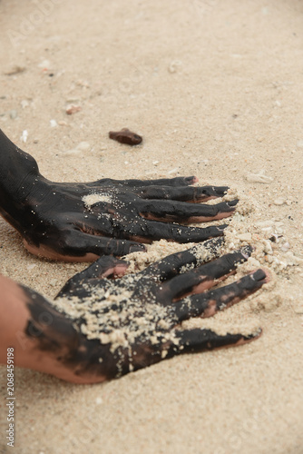 Paint Covered Hands Touching Sand on Beach Close Up