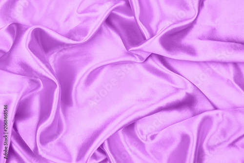 Elegant purple satin silk fabric texture background with soft ripples and folds.