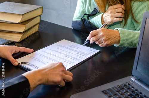Konstfotografi Close up of injured woman signing accident release form with lawyer