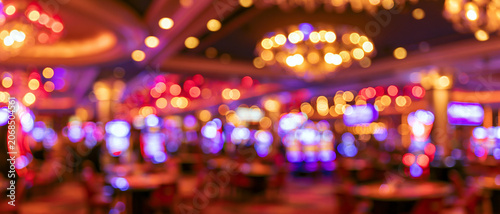 Abstrakter unscharfer Casino-Hintergrund. Defokussierte Spielautomaten mit bunten Neon-Bokeh-Lichtern. Breites Glücksspiel-Banner.