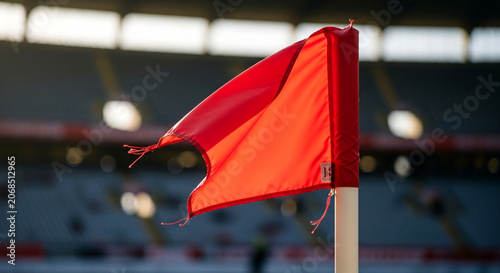 Corner flag on a soccer field with stadium seating in the background.