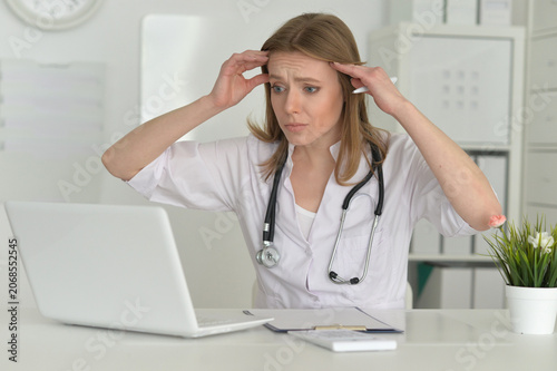 Young sad female doctor working in an office