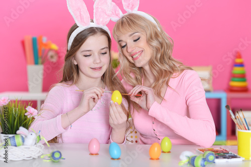Mother and daughter colouring eggs