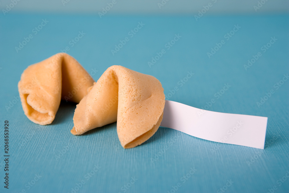 Obraz premium Two golden fortune cookies on a blue textured background with a blank