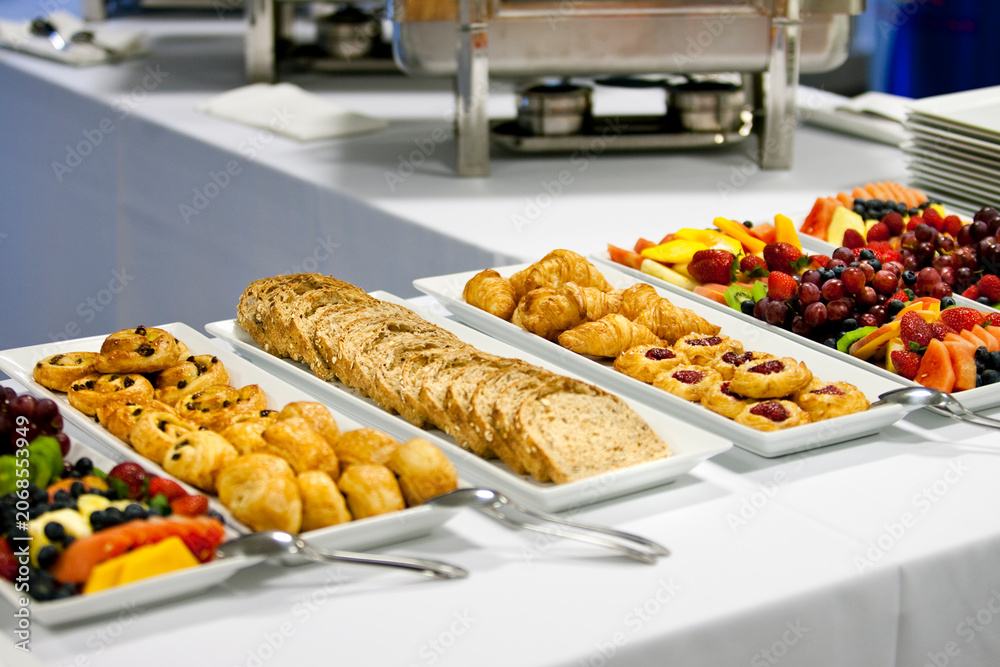 Naklejka premium Catering buffet table filled with fresh pastries, bread, and fruit