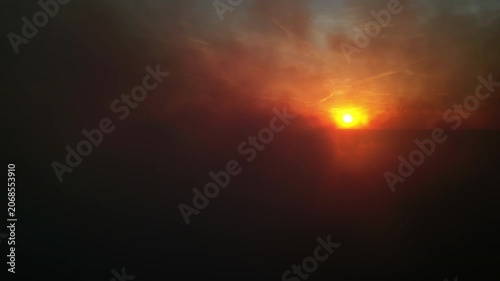 Aerial view of dramatic scene of black smoke and sun at sunset, 4k