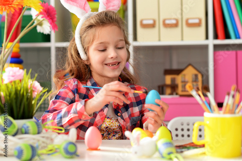beautiful girl decorating eggs for Easter holiday