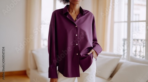 Full body Shot showing A woman fashion model from knees up. the fashion model is standing in A calm, elegant living room with warm white or cream walls, a soft beige sofa, sheer curtains