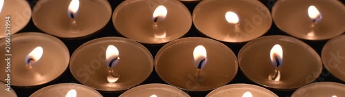 Group of burning candles providing illumination and a sense of calm during a quiet moment or spiritual event.