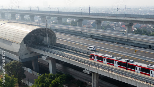 Modern Light Rail Train Arriving at Elevated Station Next to Highway