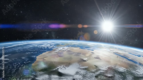 A stunning view of Earth from space showcases the planet's curvature, atmosphere, and a brilliant sunrise over a cloudy landscape.