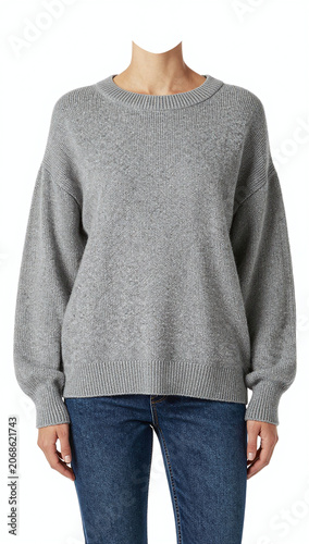 Headless female model wearing oversized sweater and jeans