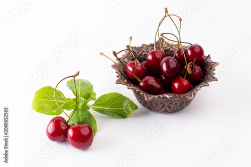 Photos front view red sour cherries inside brown plate on the white background fruit co