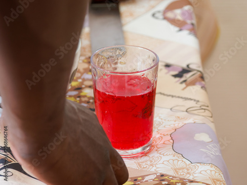 Verre de boisson rouge servi lors d’une réception de première communion ou d’une fête familiale