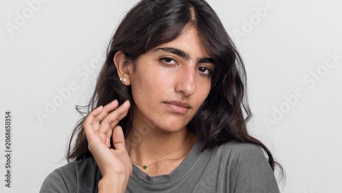 Real South Asian woman with long straight hair in grey t shirt studio portrait