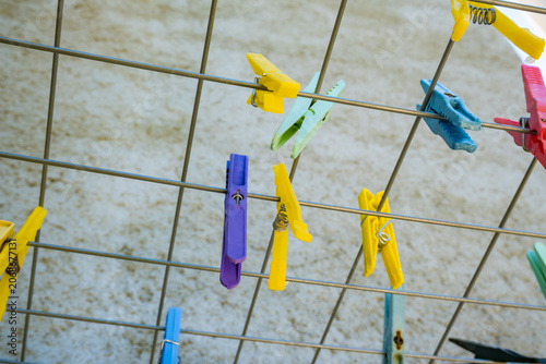 Konstfotografi Colorful clothespins hang on a metal drying rack