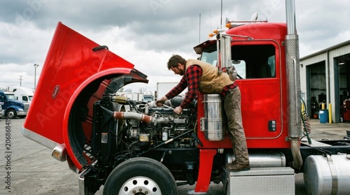 Mechanic repairing a large semi truck engine