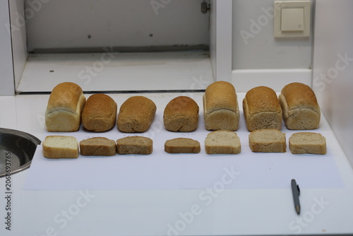 Sensory Evaluation Booth Displaying Various Experimental Bread Loaves and Slices for Hedonic Quality Analysis