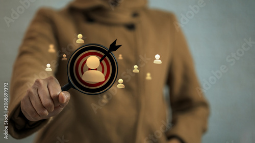 Canvas Print Person in brown coat holding magnifying glass focusing on user icon inside dartb
