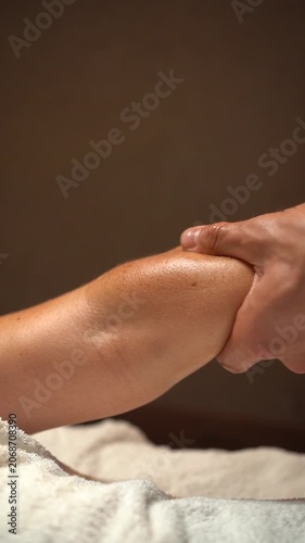 Masseuse performing a relaxing and therapeutic arm massage with oil on a client at a spa salon